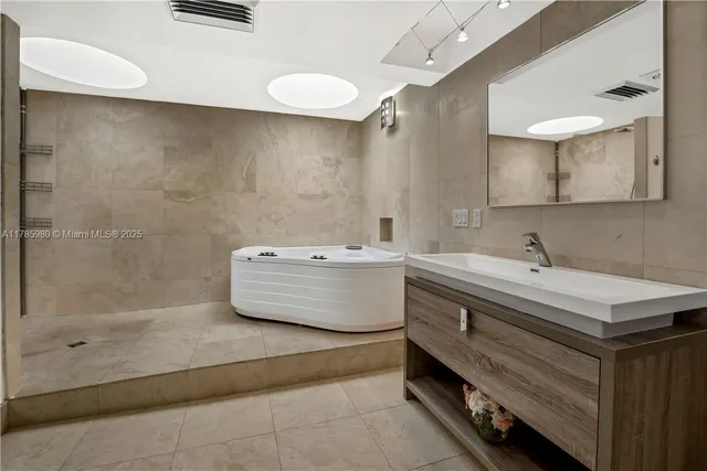 a bathroom with a double vanity sink mirror and bathtub