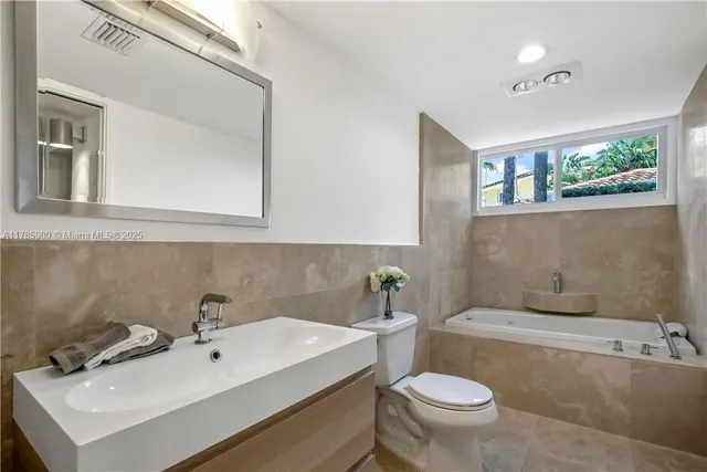 a bathroom with a sink mirror toilet and bathtub