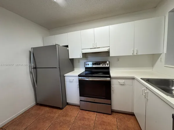 a kitchen with a refrigerator sink and cabinets