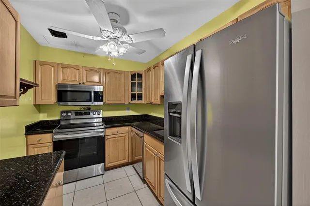 a kitchen with stainless steel appliances granite countertop a stove refrigerator and microwave