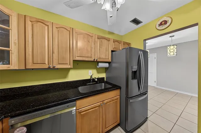 a kitchen with stainless steel appliances granite countertop a refrigerator and a stove top oven