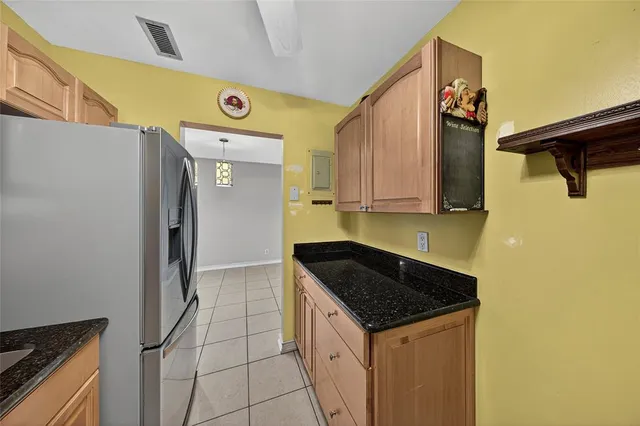 a kitchen with a sink a refrigerator and cabinets