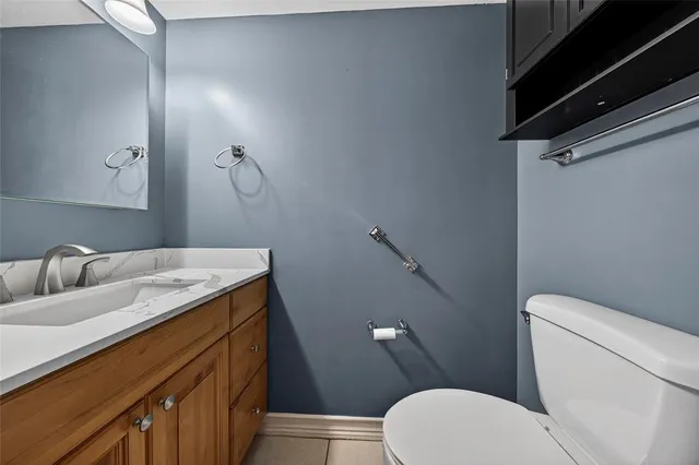 a bathroom with a granite countertop toilet sink and mirror