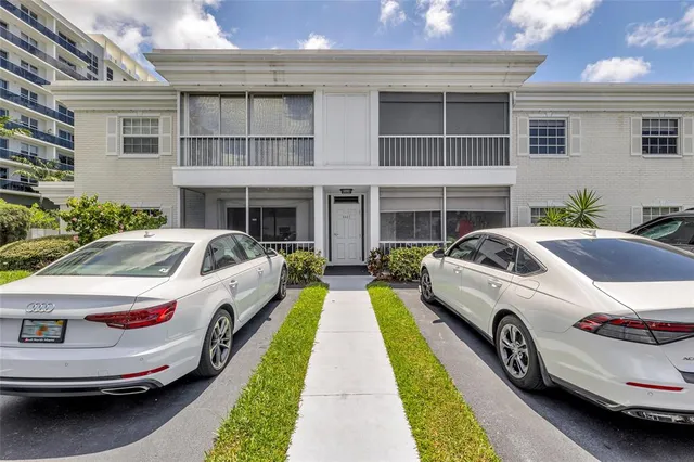 a view of a white car parked in front of a house