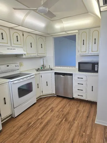 a kitchen with stainless steel appliances granite countertop a sink a stove and cabinets