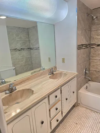 a bathroom with a granite countertop sink a toilet and bathtub