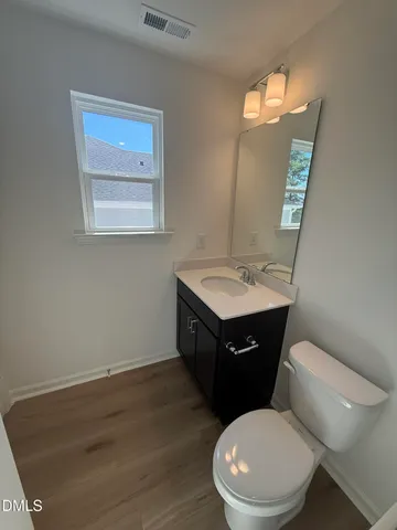 a bathroom with a toilet a sink and mirror