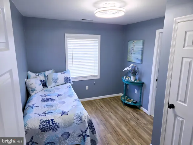 a bedroom with a bed and a lamp on dresser