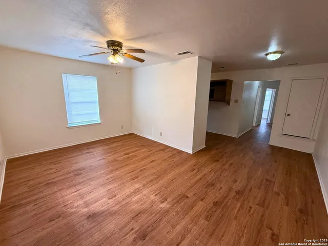 a view of empty room with wooden floor