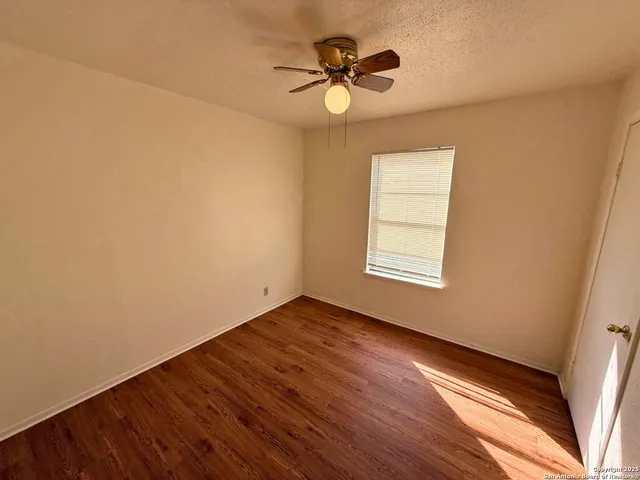 a view of an empty room with a window and a fan
