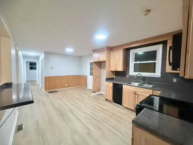 a large kitchen with stainless steel appliances granite countertop a sink and a stove