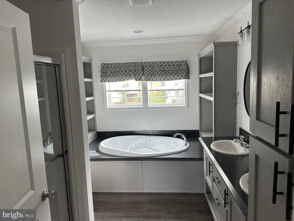 a bathroom with a sink a toilet a mirror and window