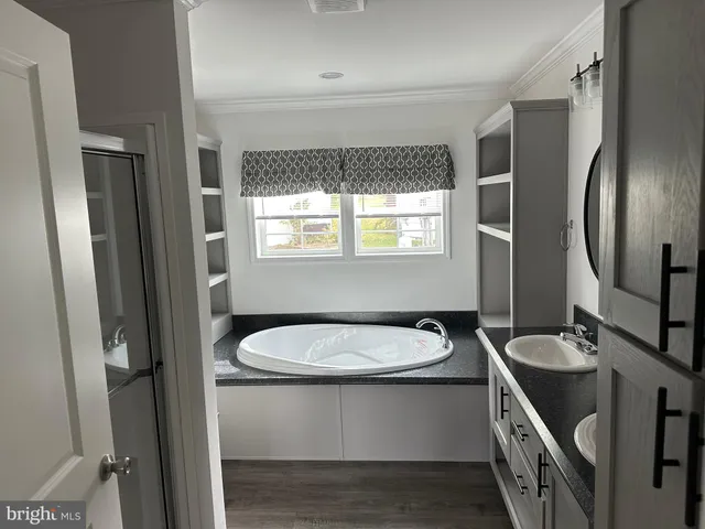 a bathroom with a sink a toilet a mirror and window