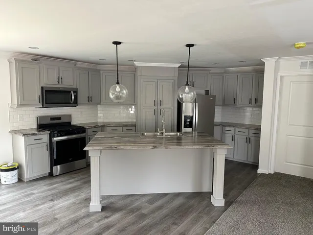 a kitchen with kitchen island a counter top space appliances and cabinets