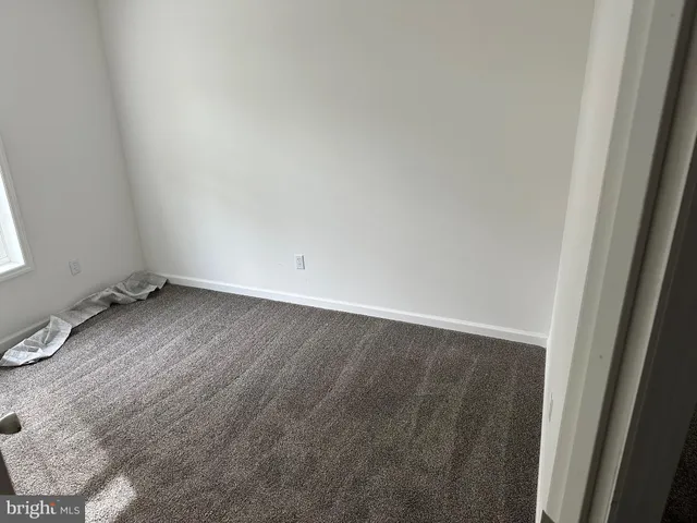 a view of a room with wooden floor and small window