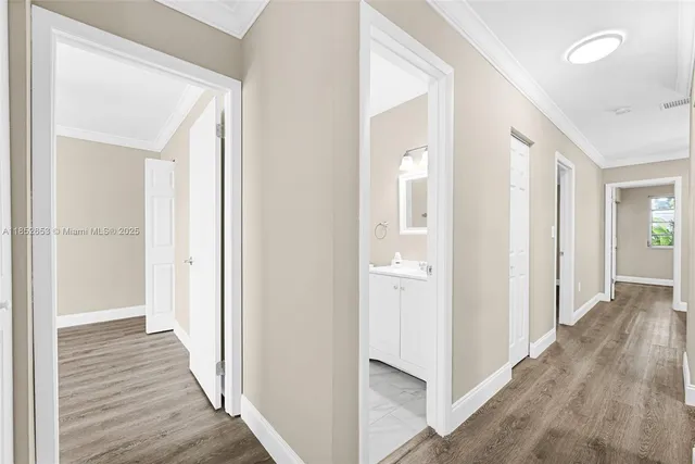 an empty room with wooden floor and fan