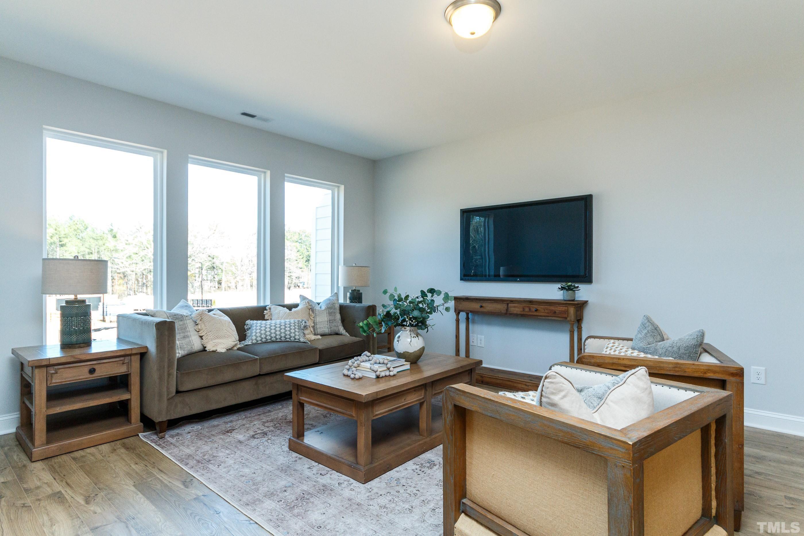 3109 Dunnock Drive, Unit 5 Durham, NC 27713 - Photo 11 of 25 a living room with furniture a flat screen tv and a large window