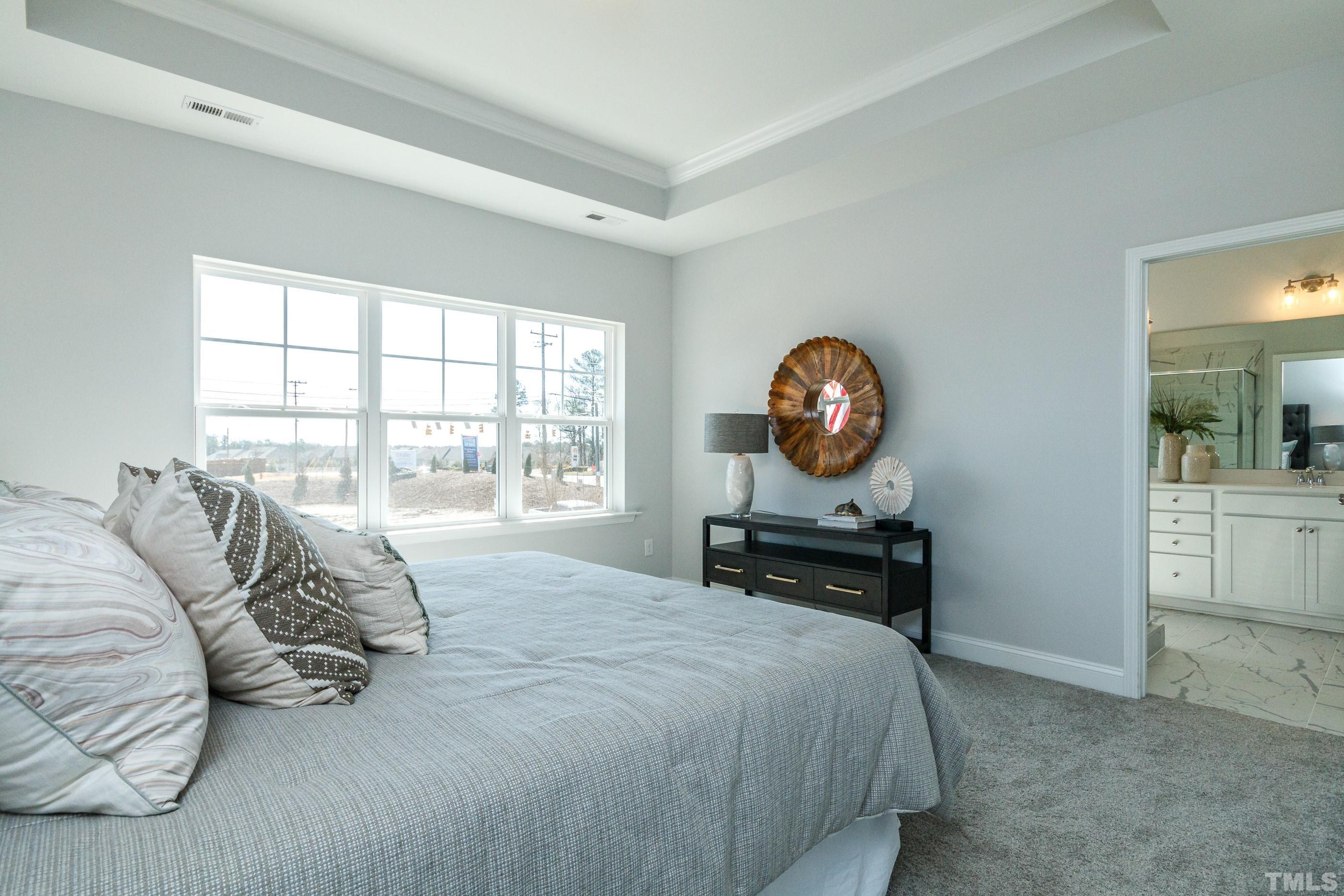 3109 Dunnock Drive, Unit 5 Durham, NC 27713 - Photo 22 of 25 a bedroom with a bed a mirror and a large window