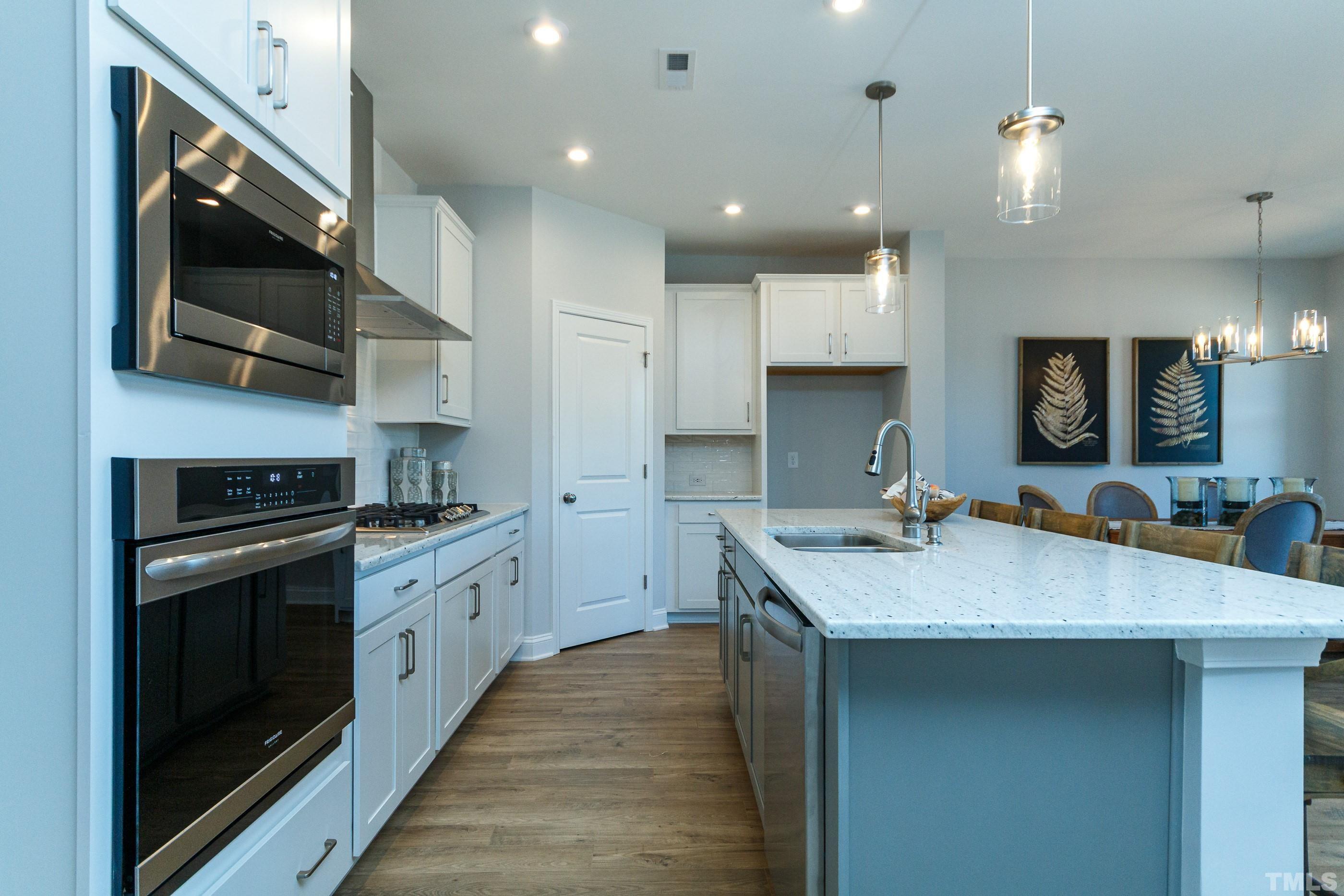 3109 Dunnock Drive, Unit 5 Durham, NC 27713 - Photo 4 of 25 a kitchen with stainless steel appliances granite countertop a sink a stove and a wooden floors
