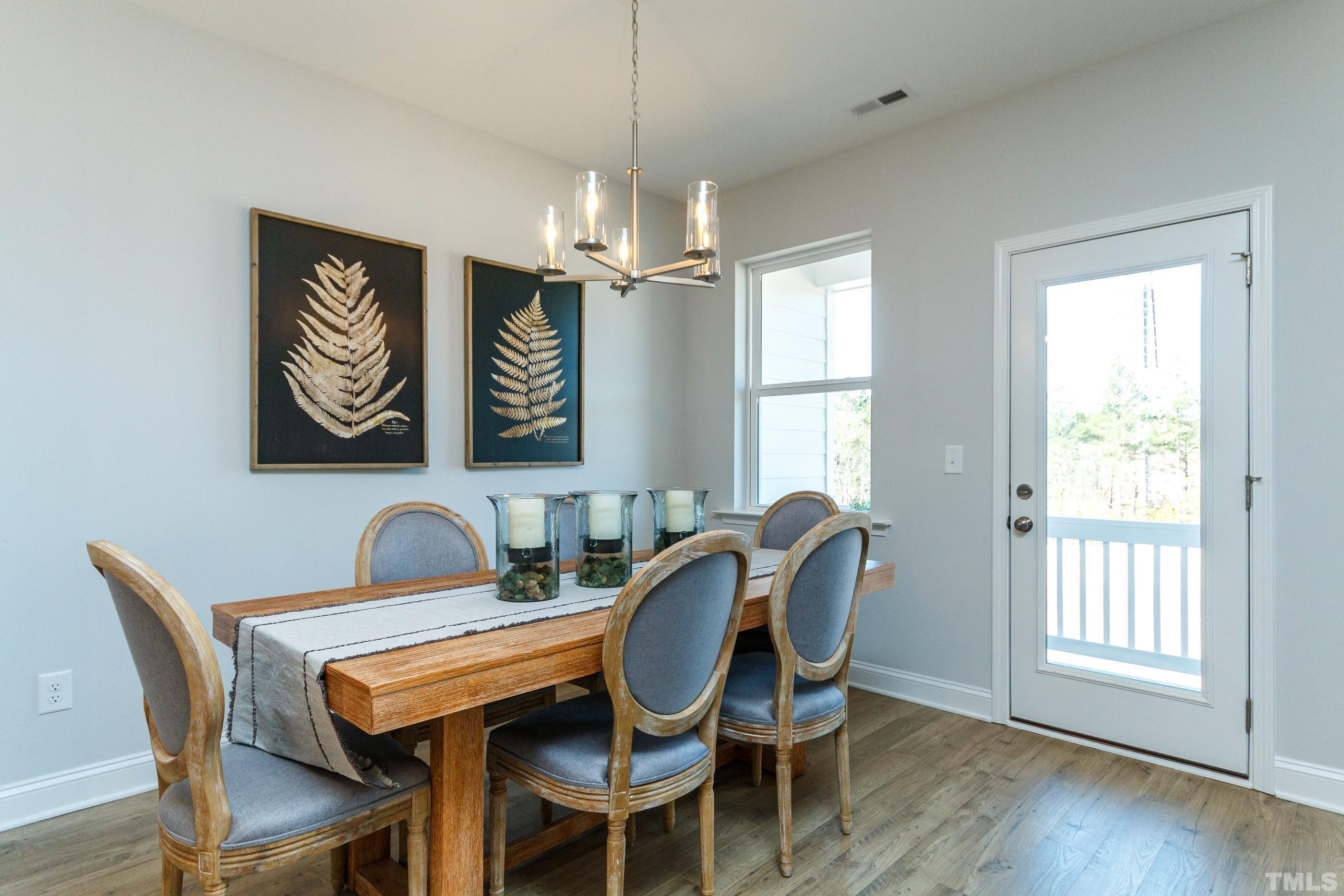 3109 Dunnock Drive, Unit 5 Durham, NC 27713 - Photo 7 of 25 a dining room with furniture a chandelier and wooden floor