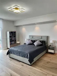 a spacious bedroom with a bed and a chandelier