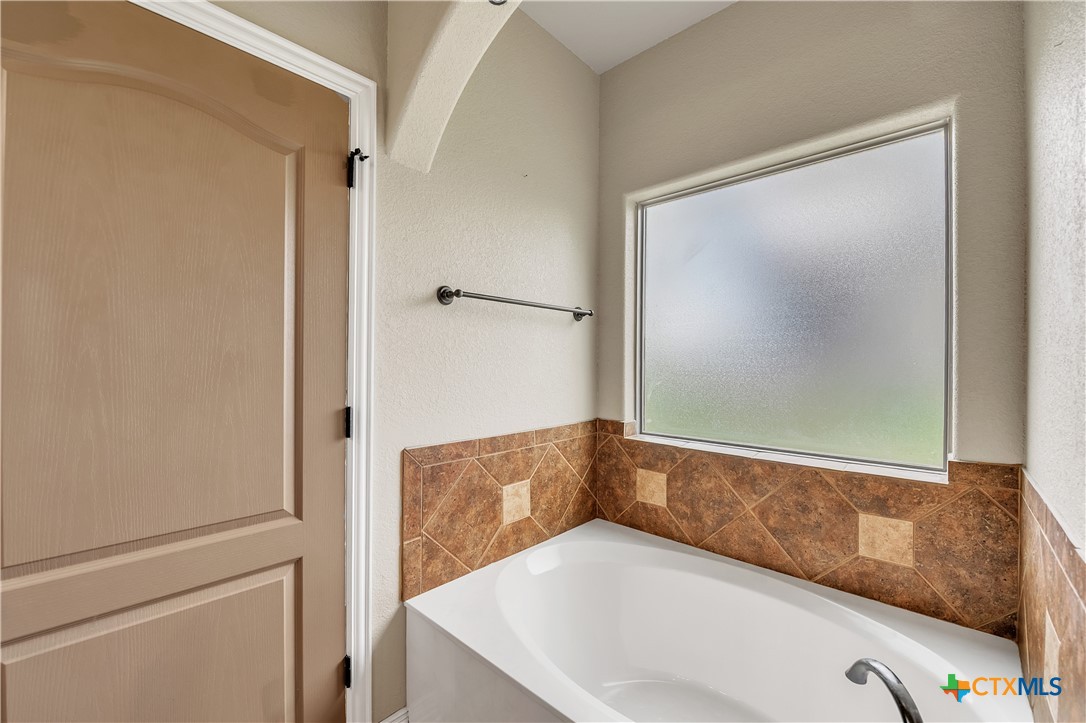 4945 Water Works Road Belton, TX 76513 - Photo 14 of 36 a bathroom with a tub and a shower