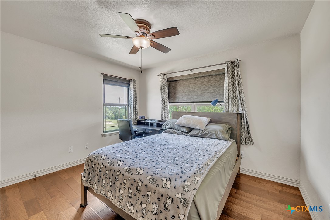 4945 Water Works Road Belton, TX 76513 - Photo 23 of 36 a bedroom with a large bed and a chandelier