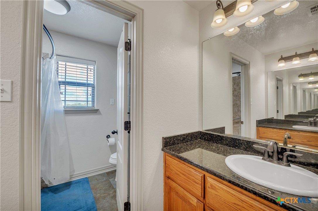 4945 Water Works Road Belton, TX 76513 - Photo 24 of 36 a bathroom with a granite countertop sink and a mirror