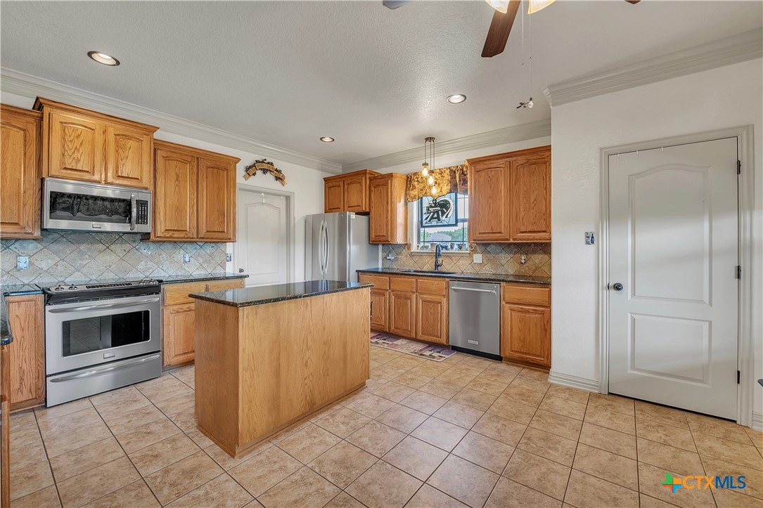 4945 Water Works Road Belton, TX 76513 - Photo 10 of 36 a kitchen with stainless steel appliances granite countertop a stove top oven a sink a counter space and cabinets