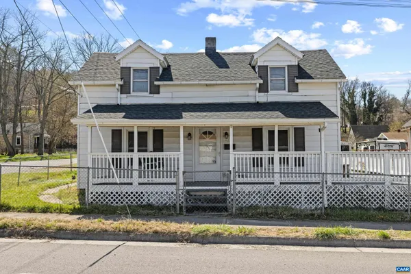 a front view of a house with a garden and fence