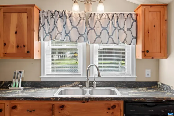 a view of a house with a small yard and wooden fence