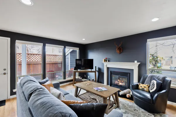 a living room with furniture large window and a fireplace