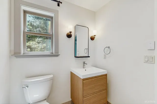 a bathroom with a toilet sink and mirror