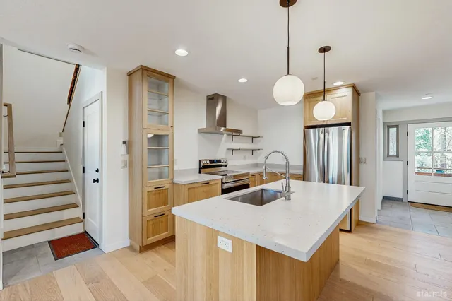 a kitchen that has a lot of cabinets and a wooden floor