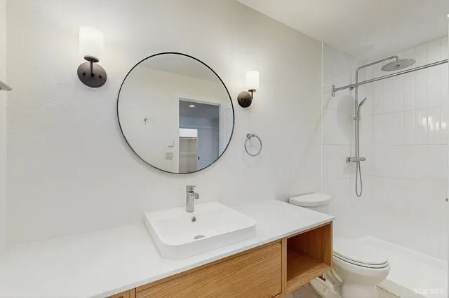 a bathroom with a sink a toilet and a mirror