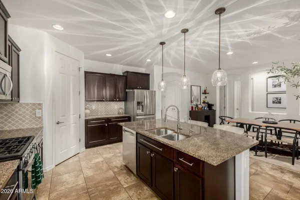 a kitchen with kitchen island granite countertop a sink a counter top space appliances and cabinets