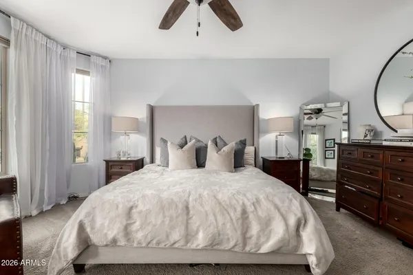 a bedroom with a bed and dresser with mirror