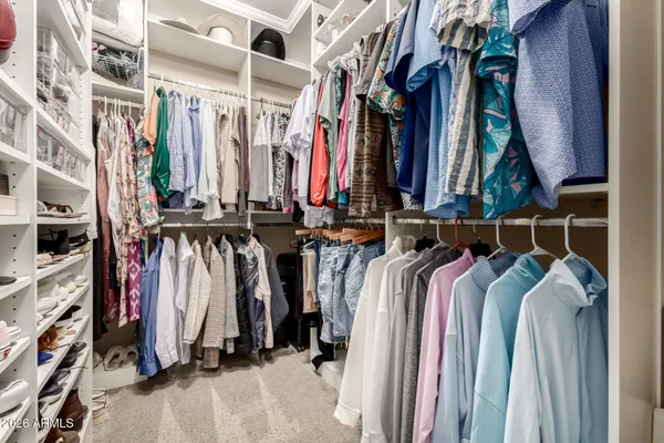 a view of walk in closet with clothes