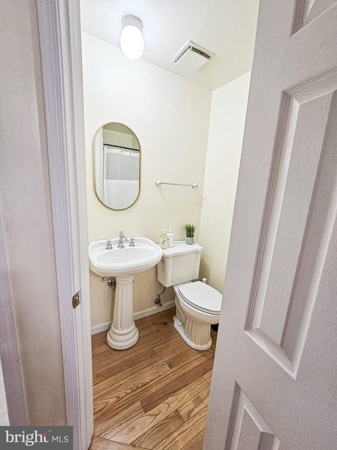 9737 Whiskey Run Laurel, MD 20723 - Photo 11 of 23 a bathroom with a sink toilet a mirror and vanity