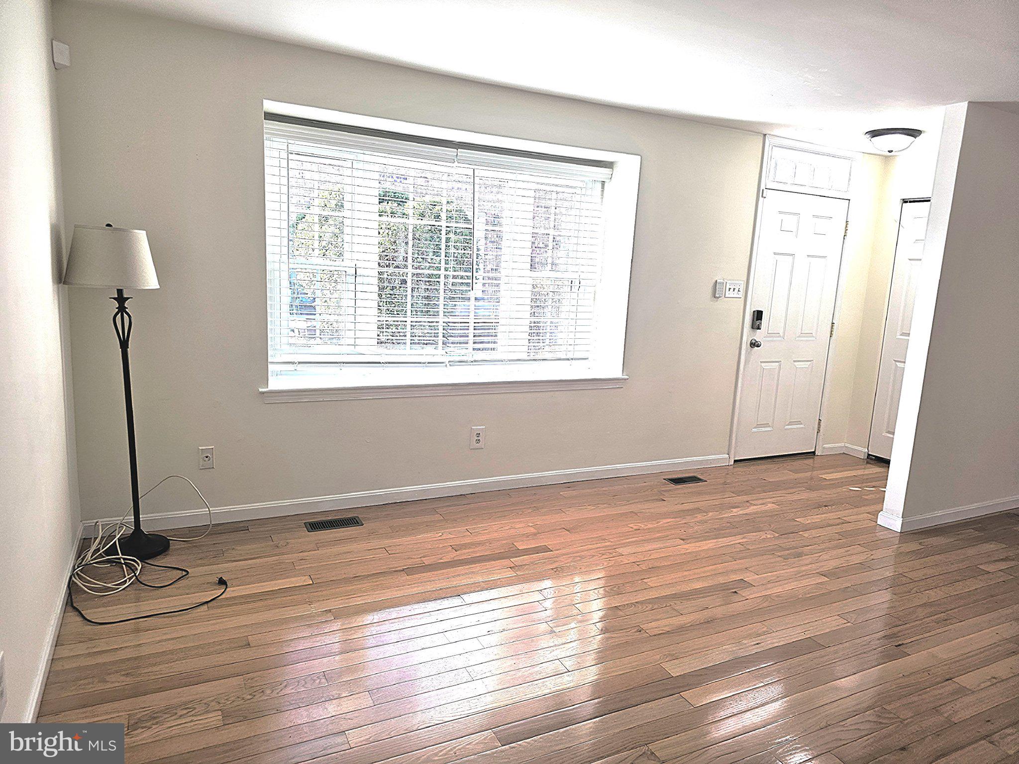 9737 Whiskey Run Laurel, MD 20723 - Photo 3 of 23 a view of an empty room with wooden floor and a window