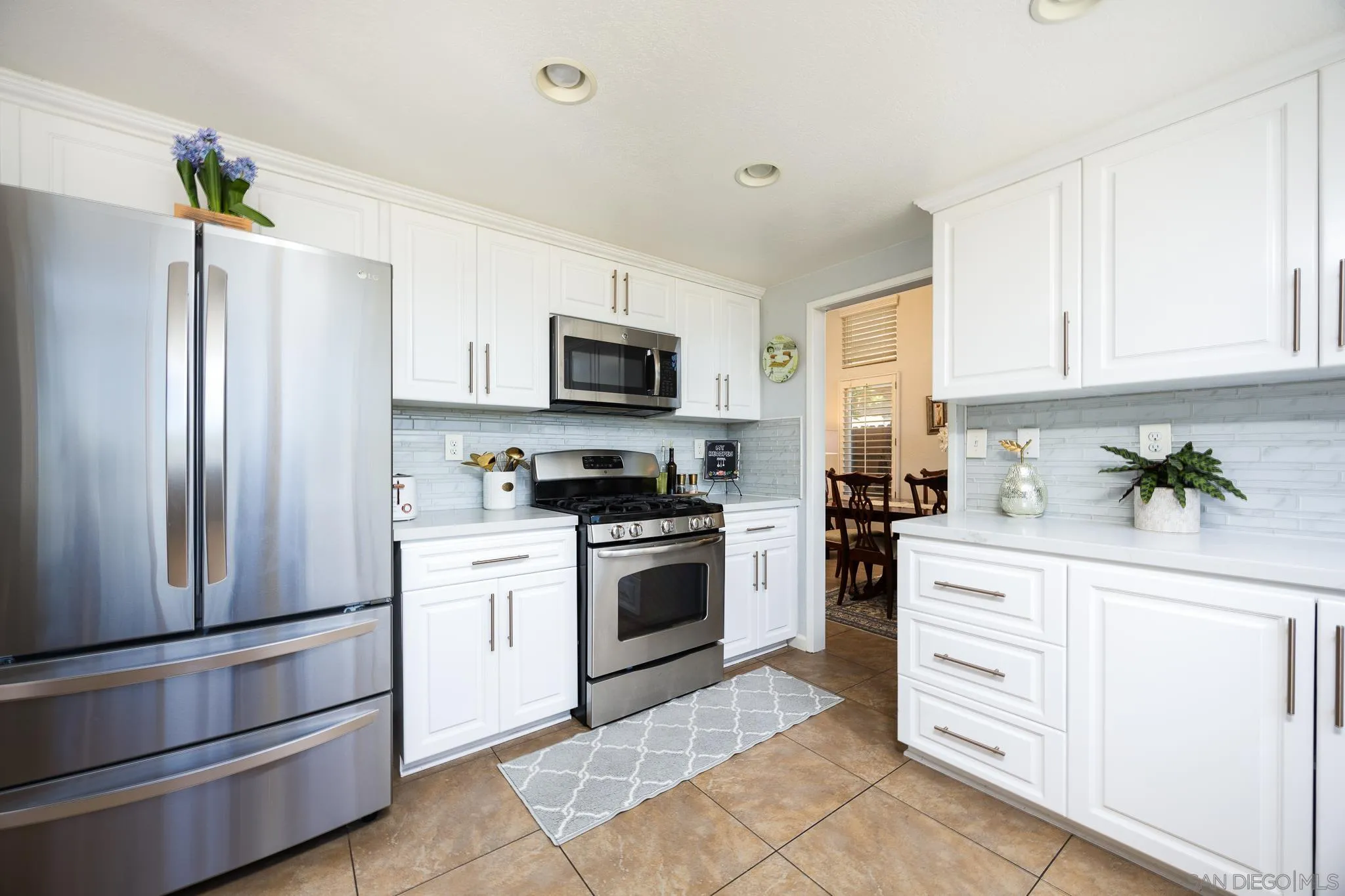 1373 Avenida Azul San Marcos, CA 92069 - Photo 12 of 33 a kitchen with white cabinets stainless steel appliances and a window