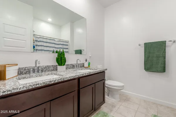 a bathroom with a granite countertop sink a mirror and vanity