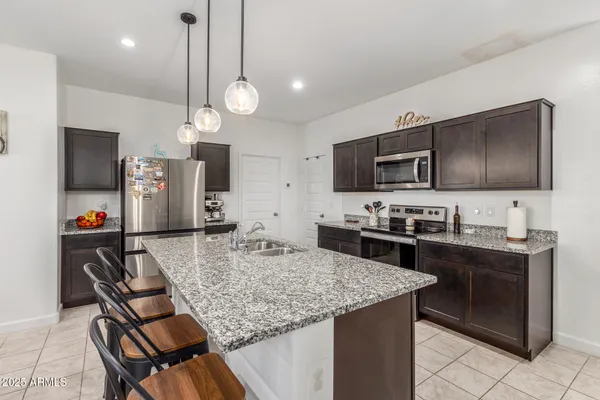 a kitchen with a table chairs microwave and cabinets