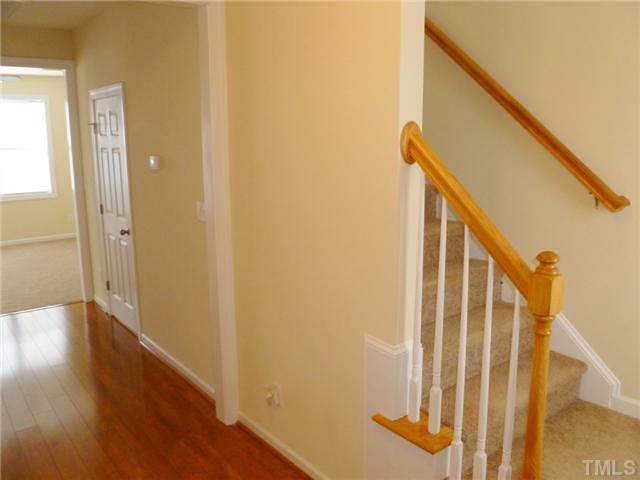 6040 Ladish Lane Raleigh, NC 27610 - Photo 4 of 21 a view of a hallway with wooden floor and staircase