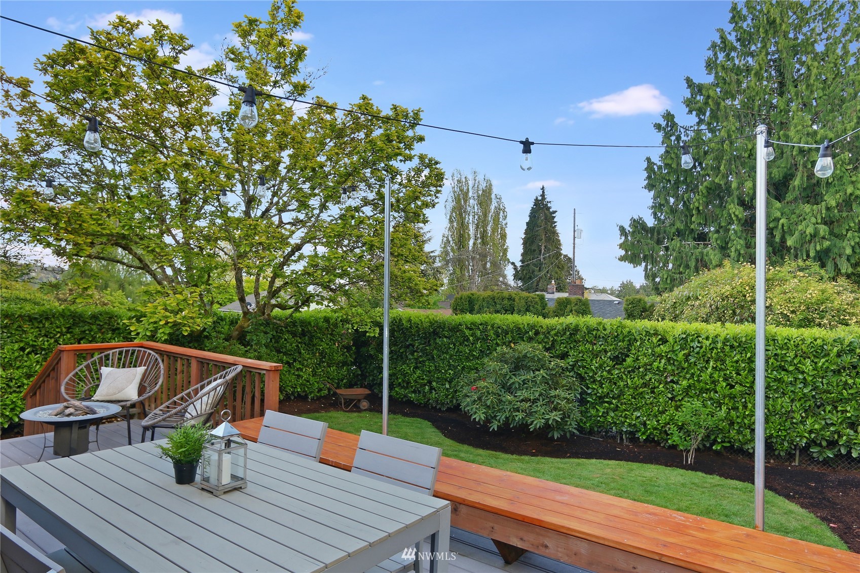 5217 South Myrtle Street Seattle, WA 98118 - Photo 15 of 30 a view of a deck with couches table and chairs with wooden floor and fence