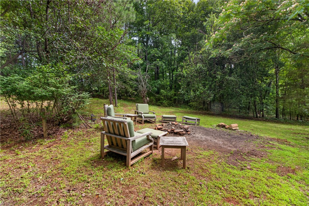 130 Maggie Rufus Lane Westminster, SC 29693 - Photo 35 of 50 An inviting fire pit area surrounded by lush greenery, perfect for outdoor gatherings.
