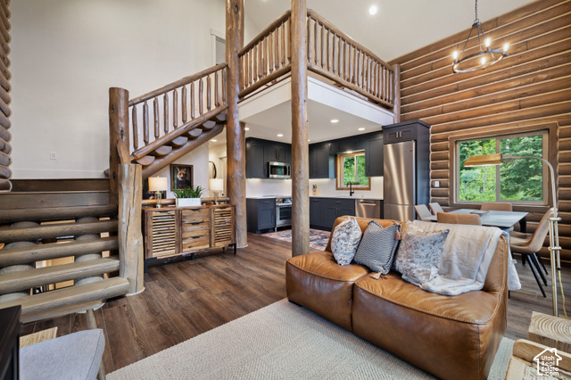 917 West Deep Forest Road Coalville, UT 84017 - Photo 2 of 41 Expansive interior featuring wood-finish flooring, log wall accents, and an open-concept kitchen with dark cabinetry