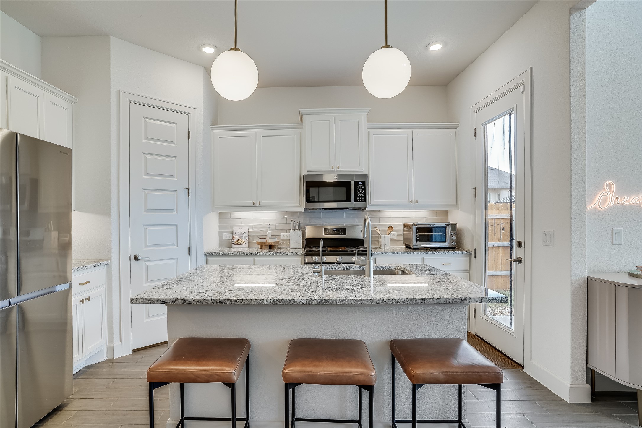 4701 Sea Salt Drive Austin, TX 78747 - Photo 11 of 29 a kitchen with stainless steel appliances granite countertop a stove a refrigerator a sink dishwasher a dining table and chairs with wooden floor