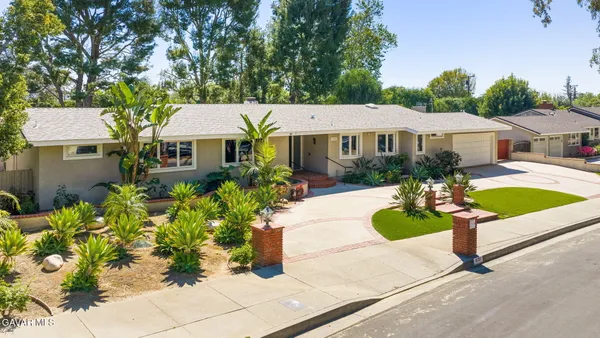 a front view of a house with a yard garden and outdoor seating