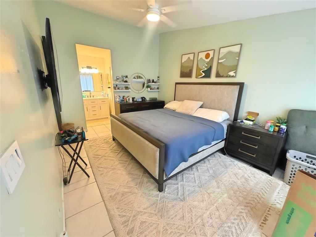 8007 Northwest 71st Court Tamarac, FL 33321 - Photo 6 of 9 a bedroom with a bed and wooden floor